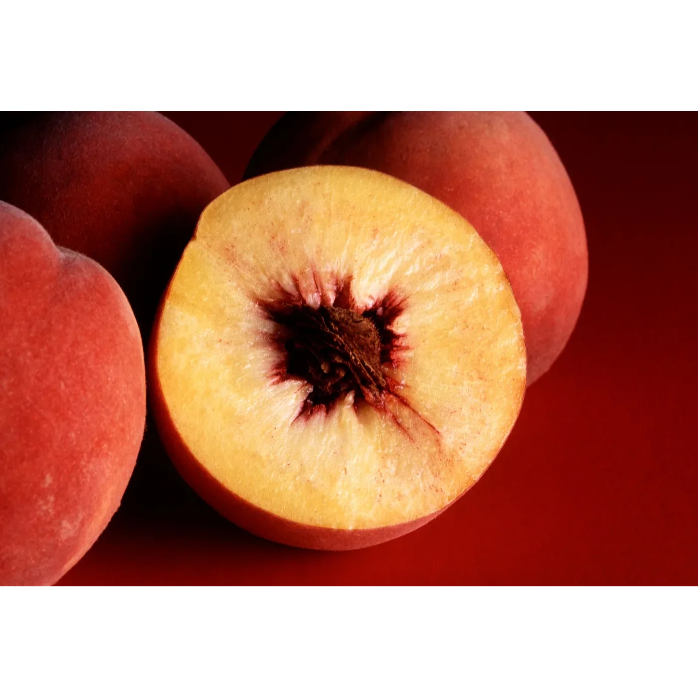 Pêssego vermelho médio cortado e inteiro